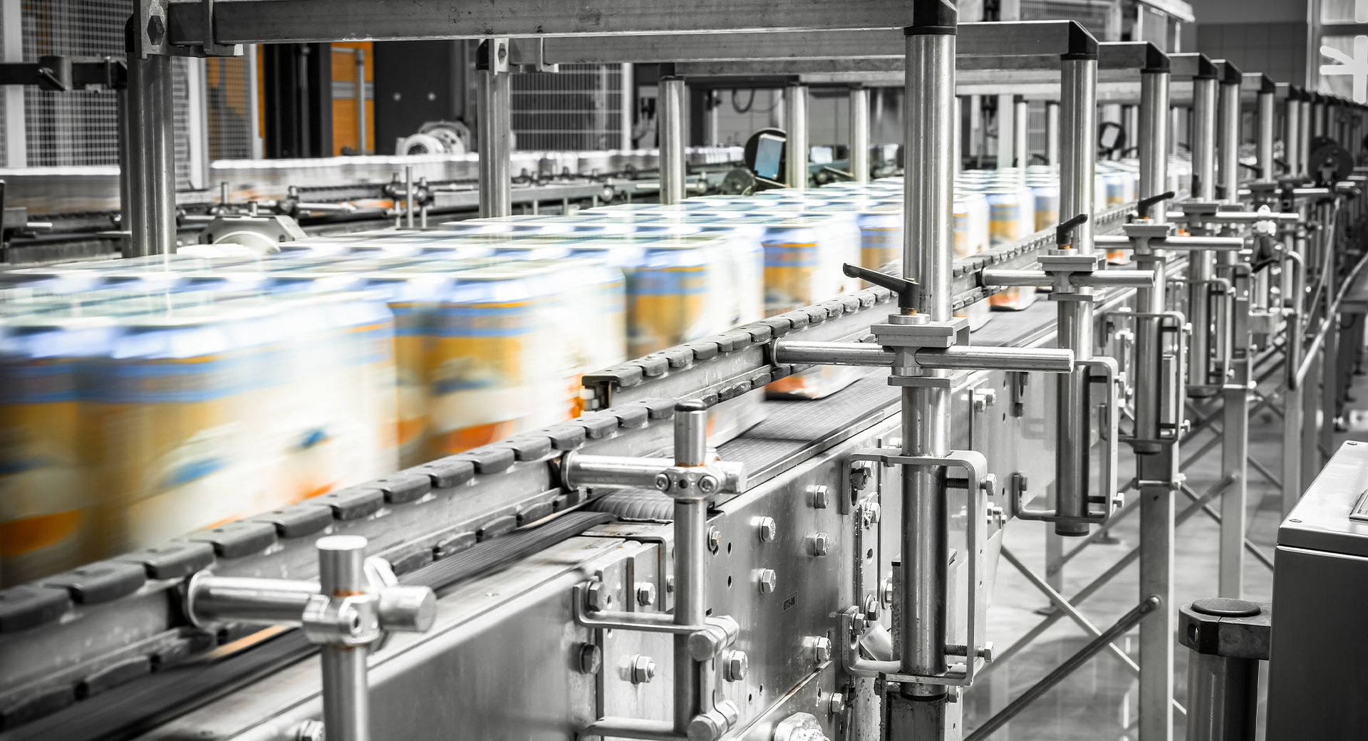 Cans going through the assembly line in batches. All the cans have labels, indicating they are moving fast.